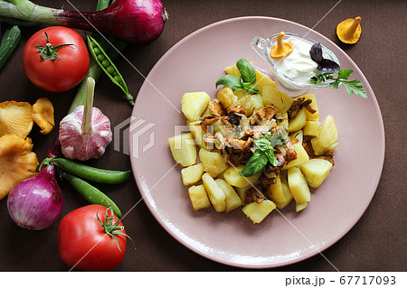 Hot dishes fried potatoes with chanterelles and vegetables close up Hot dishes fried potatoes with chanterelles and vegetables close up 67717093