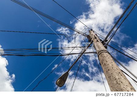 Looking up at a chaotic telegraph pole 67717284
