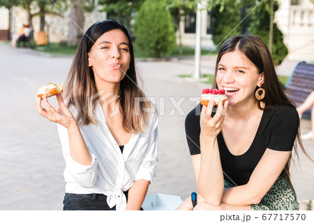 portrait of two beautiful girls friends enjoying 67717570
