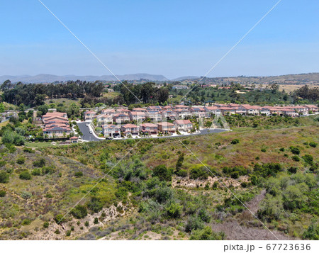 Aerial view of upper middle class neighborhood with residential houses in green valley Aerial view of upper middle class neighborhood with residential houses in green valley 67723636
