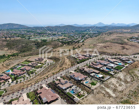 Aerial view of high class neighborhood with residential villas and swimming pools in dry valley  67723655