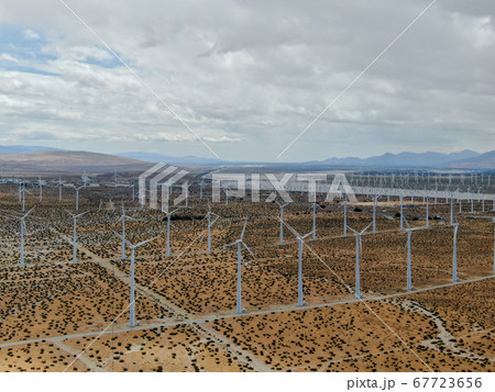 Aerial view of huge array of gigantic wind turbines spreading over the desert in Palm Springs. Aerial view of huge array of gigantic wind turbines spreading over the desert in Palm Springs. 67723656