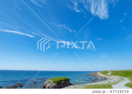 【青森県下北半島尻屋崎】白亜の灯台に続く津軽海峡沿いの道と青空 67728259