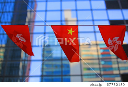 chinese and hong kong flags blow in the wind with glass building background 67730180