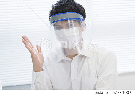 フェイスシールド マスクのビジネスマン 打ち合わせイメージ フェイスシールド マスクのビジネスマン 打ち合わせイメージ 67731002