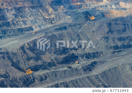 Huge iron ore quarry with working dump trucks 67731043