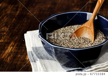Chia seeds in a bowl with wooden spoon Chia seeds in a bowl with wooden spoon 67733384