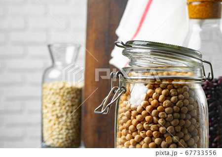 Uncooked dried chickpeas in glass jar close up 67733556