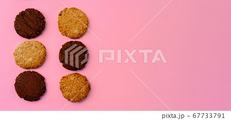 Chocolate cookies and oat cookies on pink background with copy space 67733791