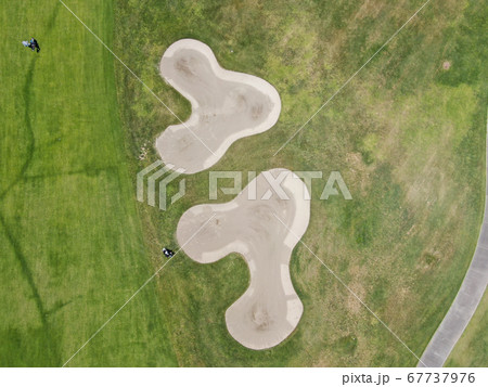 Aerial top view of a green golf course during sunny day 67737976