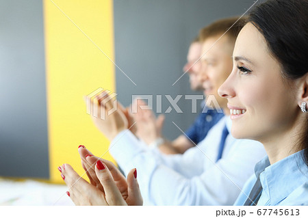 Business woman and businessmen sit and clap their hands. Business woman and businessmen sit and clap their hands. 67745613