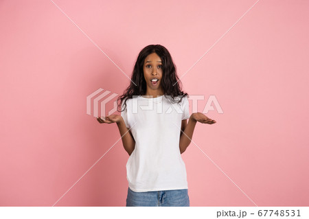 Cheerful african-american young woman isolated on pink background, emotional and expressive Cheerful african-american young woman isolated on pink background, emotional and expressive 67748531