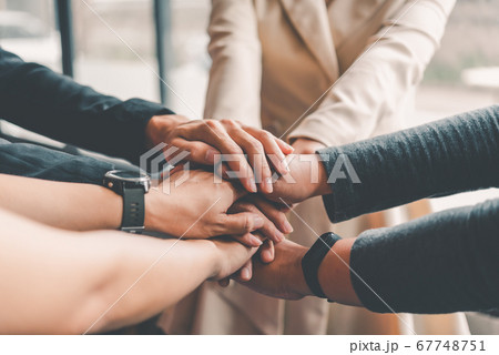 Hands of business people come together in a stack 67748751