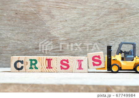 Toy forklift hold letter block s to complete word crisis on wood background 67749984