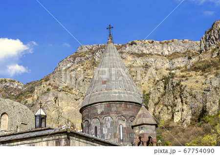 All domes with crosses and a cave church with carved khachkars on the walls, in the Geghard monastery in Armenia  67754090