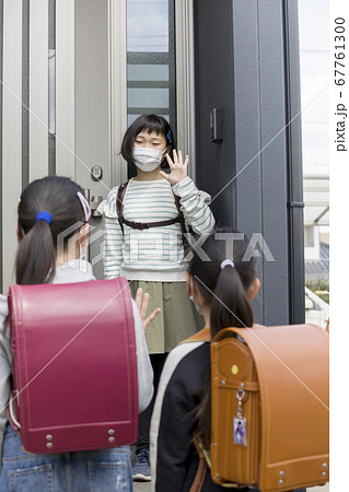 友達の家に迎えに行く小学生女の子 通学イメージ マスク着用の写真素材