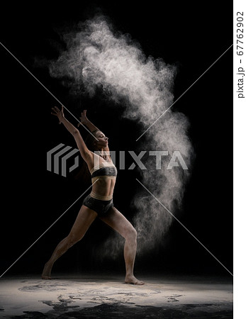 Slim female dancer throwing dust in air 67762902