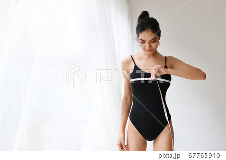 healthy and slim woman taking measurements of her breast 67765940