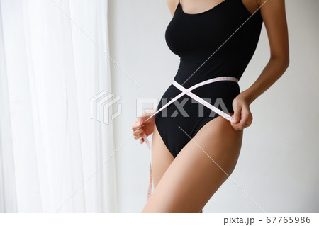 closeup healthy and slim woman taking measurements of her body closeup healthy and slim woman taking measurements of her body 67765986