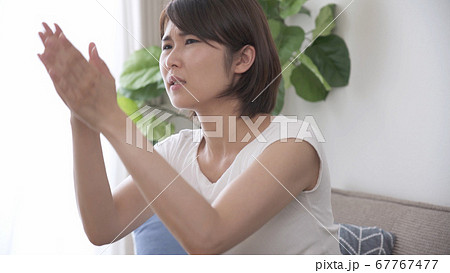 蚊を叩く若い女性 67767477