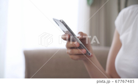 家でスマートフォンを操作する女性 67767485