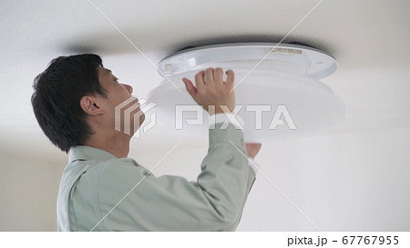 照明器具を取り付ける男性 67767955