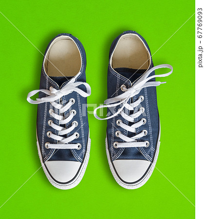 Blue sneakers isolated on green background 67769093