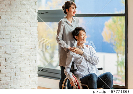 車椅子の男性と女性のカップル  67771863