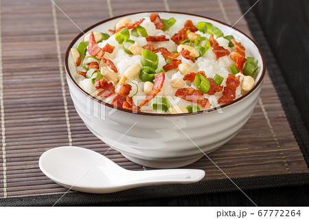 Asian rice porridge with bacon, peanuts and green 67772264