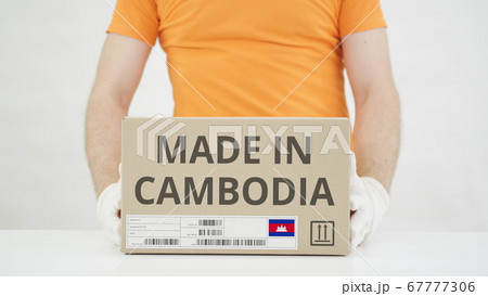 Carton with MADE IN CAMBODIA text being placed on the table 67777306
