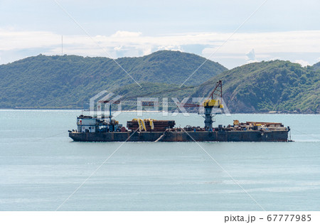 Offshore Barges with crane and Platform Supply Vessel mooring near island 67777985