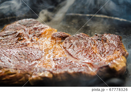 牛肉・アンガス牛の肩ロースステーキを鉄板で焼く 67778326