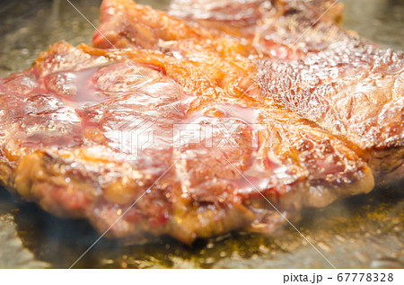 牛肉・アンガス牛の肩ロースステーキを鉄板で焼く 67778328