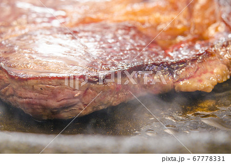 牛肉・アンガス牛の肩ロースステーキを鉄板で焼く 67778331