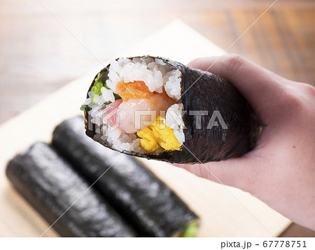 恵方巻きを持つ女性の手 恵方巻きを持つ女性の手 67778751