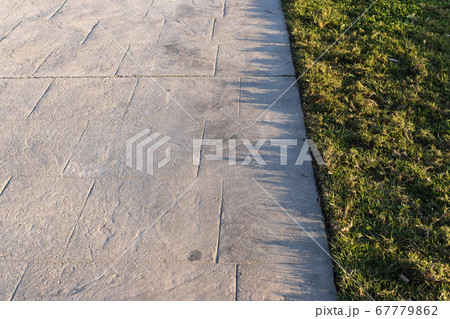 Stamped concrete pavement outdoor with an expansion joint at top, decorative appearance colors and textures of paving slate stone tile on cement Stamped concrete pavement outdoor with an expansion joint at top, decorative appearance colors and textures of paving slate stone tile on cement 67779862