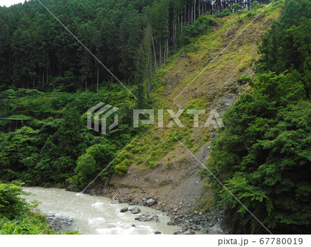 崖崩れが起こった山肌と河川 67780019