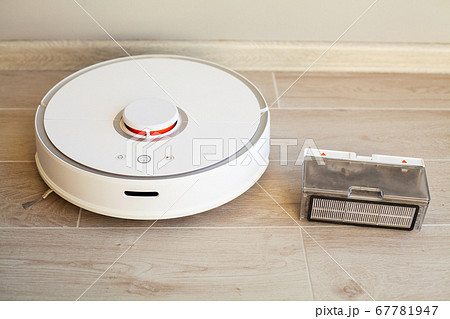 Smart House. Vacuum cleaner robot runs on wood floor in a living room 67781947