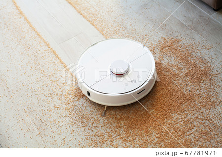 Smart House. Vacuum cleaner robot runs on wood floor in a living room Smart House. Vacuum cleaner robot runs on wood floor in a living room 67781971