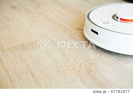 Smart House. Vacuum cleaner robot runs on wood floor in a living room 67781977