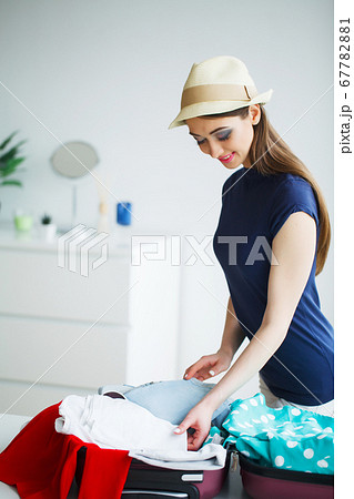 Woman goes on vacation and puts on clothes in suitcase Woman goes on vacation and puts on clothes in suitcase 67782881