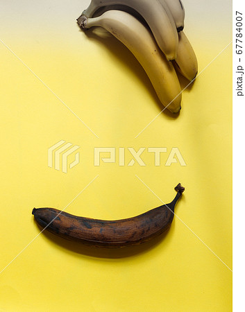 one spoiled banana and a bunch of fresh bananas on a yellow background, top view one spoiled banana and a bunch of fresh bananas on a yellow background, top view 67784007
