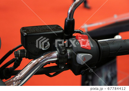 KUALA LUMPUR, MALAYSIA -JULY 25, 2019: Motorcycle ignition and engine kill button. Placed at the right-hand side of the motorcycle handle. It is usually red. 67784412