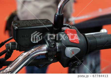KUALA LUMPUR, MALAYSIA -JULY 25, 2019: Motorcycle ignition and engine kill button. Placed at the right-hand side of the motorcycle handle. It is usually red. KUALA LUMPUR, MALAYSIA -JULY 25, 2019: Motorcycle ignition and engine kill button. Placed at the right-hand side of the motorcycle handle. It is usually red. 67784413
