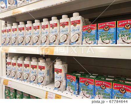KUALA LUMPUR, MALAYSIA -JUNE 4, 2020: Processed coconut milk packed in the small commercial paper box and displayed for sale on a steel rack inside the supermarket. Sorted by brand.  67784644