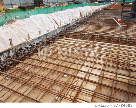 KUALA LUMPUR, MALAYSIA -MARCH 3, 2020: Building floor slab under construction. Construction workers fabricating the timber formwork and installing the steel reinforcement bar.  67784685