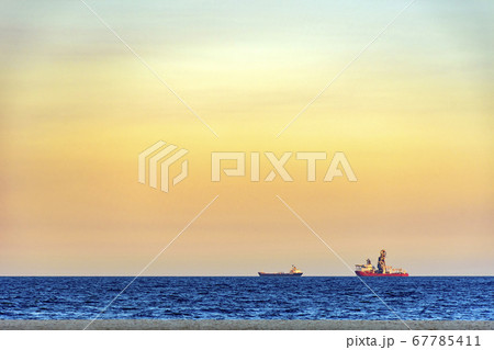 Ships on the horizon during sunset Ships on the horizon during sunset 67785411