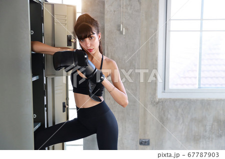 sporty caucasian girl in black sport wear and black boxer gloves posing for portrait with sexy eyes 67787903