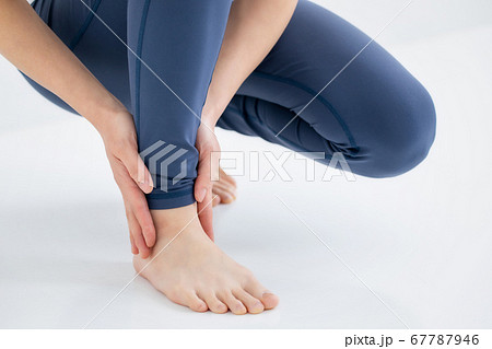 足首をおさえる女性 67787946