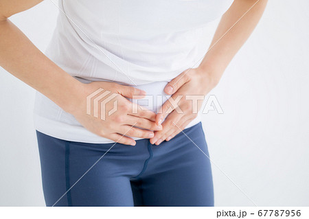 お腹をおさえる女性 67787956